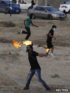 Anti-government protester throws a petrol bomb at riot police in Salambad, south of Manama (