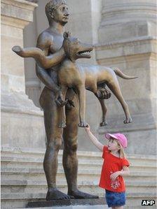 Little girl looks at wolf