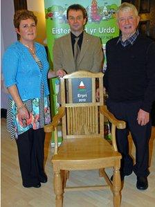 Bethan Jones Parry yn cyflwyno'r Gadair er cof am ei thad a'i brawd i Aled Sion, Cyfarwyddwr Eisteddfod Genedlaethol yr Urdd, gafodd ei gwneud gan Llewelyn Wyn Jones