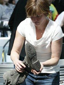 Woman removes her shoes at airport security for footwear check