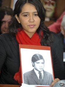 Victoria Montenegro holds a photograph of her father