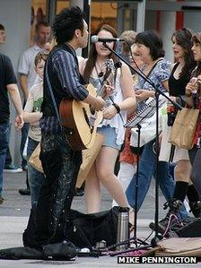 A busker performing in Liverpool's Church Street