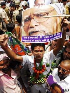 A supporter of India's opposition National Democratic Alliance holds a poster of Indian Prime Minister Manmohan Singh holds a poster during a rally in Patna on May 31, 2012,