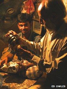 A man inspecting an auction item at night.