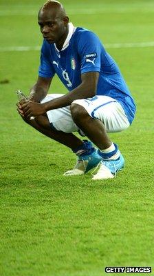 Mario Balotelli squatting on pitch