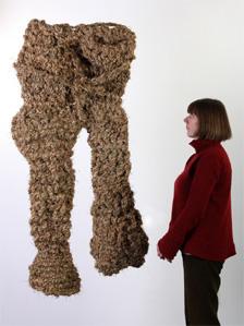 Woman looking at trousers woven from grass by Angus MacPhee