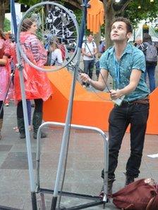 Andy Dangerfield playing games made from scrap metal outside National Theatre