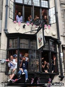 People waving flags from a pub