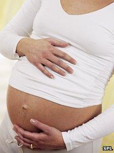 A pregnant woman holding her tummy