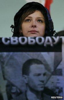 A protester holds a placard with a photo of Vladimir Akimenkov in Moscow, 30 October