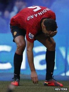 Rio Ferdinand picks up an object from the pitch