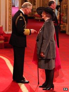 April Ashley receiving her MBE medal from Prince Charles