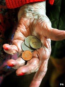 Elderly hand holding coins