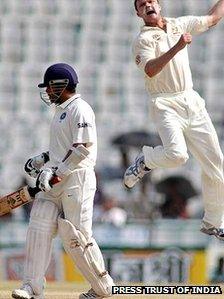 Australia's Doug Bollinger, right, jumps to celebrate the dismissal of Sachin Tendulkar, during the final day of their first cricket test match in Mohali. Chasing 216 to win, India were 162 for eight wickets in their second innings at lunch.