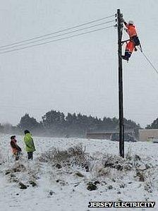 Jersey Electricity engineer up an overhead cable fixing it after heavy snowfall and strong winds