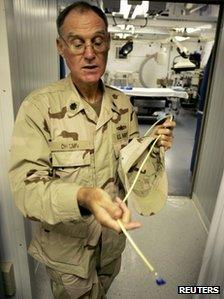 Military doctor at Camp Delta, Guantanamo Bay, holds out a feeding tube on 26 April