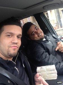 This photo obtained on 10 May 10 2013, by the US Attorney’s Office in New York shows defendants Elvis Rafael Rodriguez (left) and Emir Yasser Yeje as they pose on 25 March 2013 with what Federal prosecutors said was stolen money