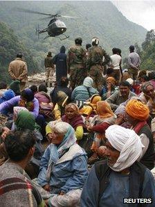 Stranded people wait for their turn to be rescued by a helicopter in Uttarakhand on 23 June 2013