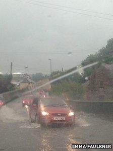 Cars drive through floodwaters