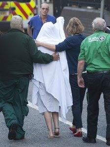 One of the victims, with head and face covered, arrives at Chelsea and Westminster Hospital,