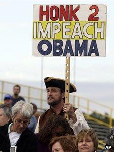 A man holds a sign reading "Honk 2 impeach Obama" at a Republican rally in New Jersey on 12 October 2013