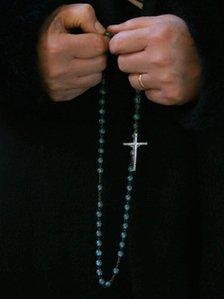 Person holding rosary beads