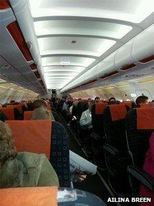 Passengers sit on a plane at Belfast International Airport waiting for their flight to take off