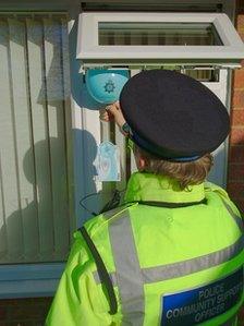 Police officer putting balloon through open window