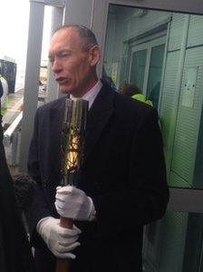 Sports Minister John Griffiths holds the Queen's Baton