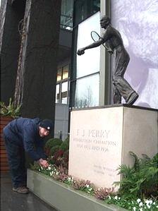 Tending to the flower bed at the Fred Perry statue