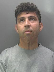 Ako Mohammad: A police image of a man with dark curly hair wearing a grey, round-necked T-shirt.
