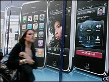 Woman walking past advert for the iPhone in London