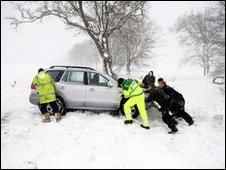 Motorists try to dig out vehicles from heavy snow on the A702 road south of Edinburgh