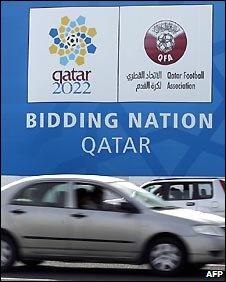 Car passing Qatar bid poster in Doha