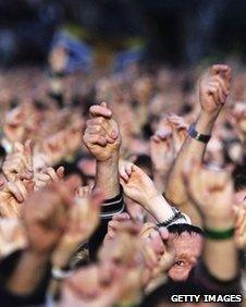 People waving their hands at a gig