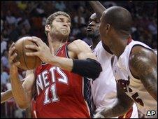 Miami Heat's players apply pressure on New Jersey Nets' Brook Lopez