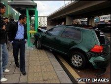 People gather at the scene of a car crash at a bus shelter next to where Gordon Brown and his cabinet were launching a poster campaign on April 30, 2010 in Birmingham,