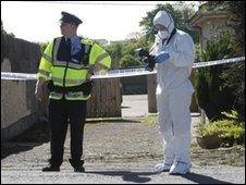 Garda officer and forensic expert at the scene of the bomb find