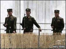 North Korean soldiers patrol the banks of the Yalu River, opposite the Chinese border city of Dandong, 25 May 2010