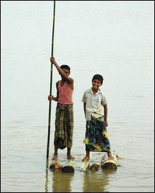 Two boys on a makeshift bamboo raft