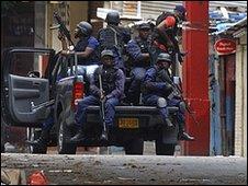 Jamaican police patrol a market area near the Tivoli Gardens