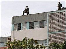 Soldiers stand on lookouts on the rooftop of buildings in the Tivoli Gardens