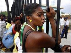 A woman waits for news of her son at the gates to Jamaica's National Stadium