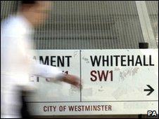 Man passes Whitehall street sign