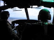 Anti-narcotics officers in a helicopter on a reconnaissance mission