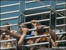 Mourners look at the coffins of fire victims