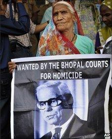 An elderly survivor holds a poster of Warren Anderson as she waits for a verdict in Bhopal, India, Monday, June 7, 2010