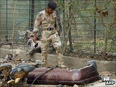 An Iraqi soldier inspects the scene of a car bomb explosion in Baghdad