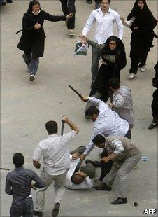 Iranian plainclothes policemen beat an election protester in Tehran, 14 June 2009