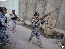 Iraqi policemen prepare to secure the scene of bombings in central Baghdad, Sunday, June 13, 2010.